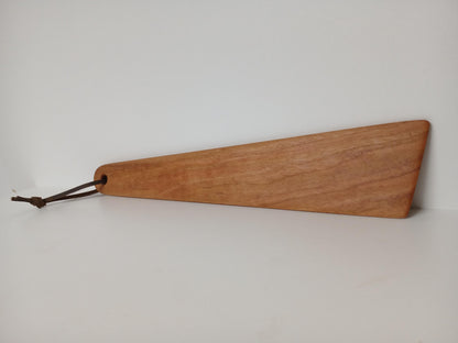 Cherry Wood Turner or Flat Spatula finished with natural oil shown on the side view, tied with a leather hanging strand