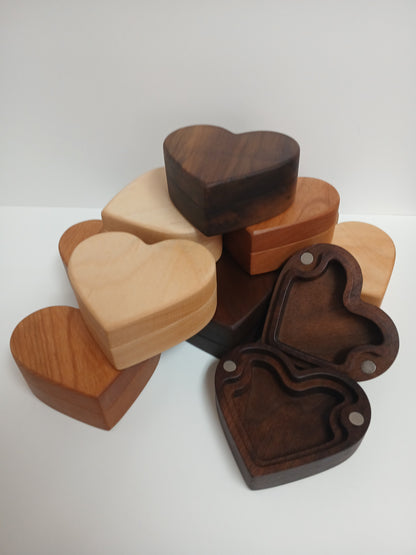 A collection of heart-shaped wooden keepsake boxes in various wood tones, including dark walnut, hard maple, alder wood, and cherry. All placed with a white background.
